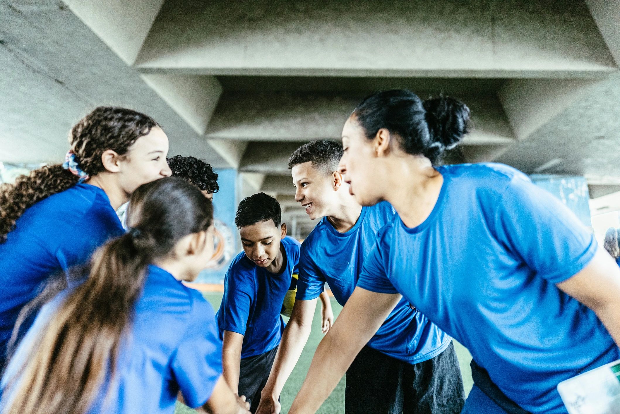 Football team with hands together in a huddle