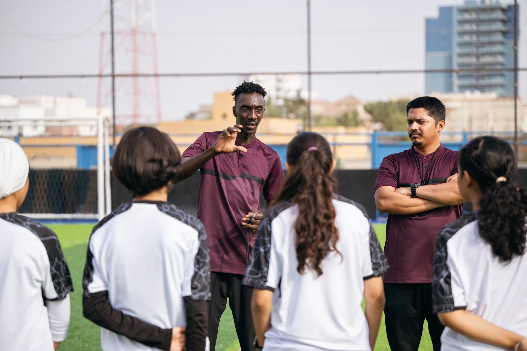 Coach giving instructions to youth football players at training